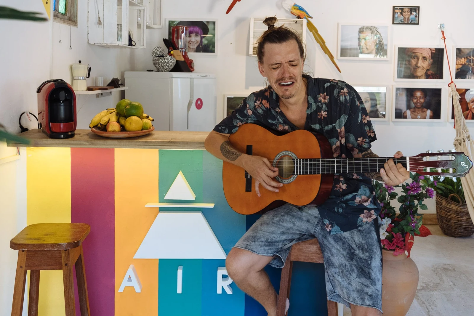 A musician holding a guitar with an exaggerated crying expression at the AIR counter.