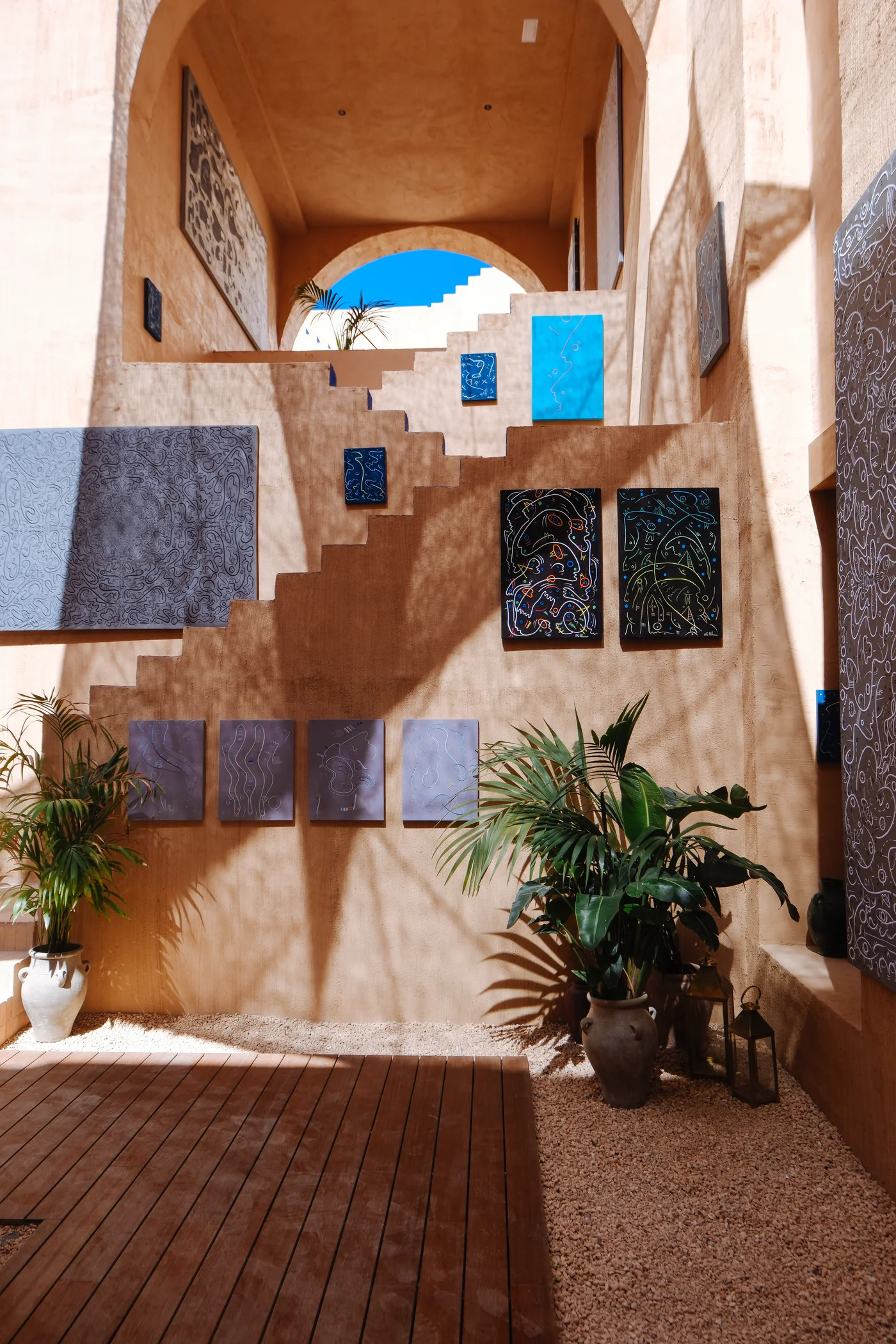 Embroidered works installed across the courtyard walls at Nômade Temple